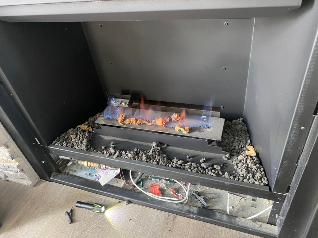 Gas fireplace being tested after repair with logs removed