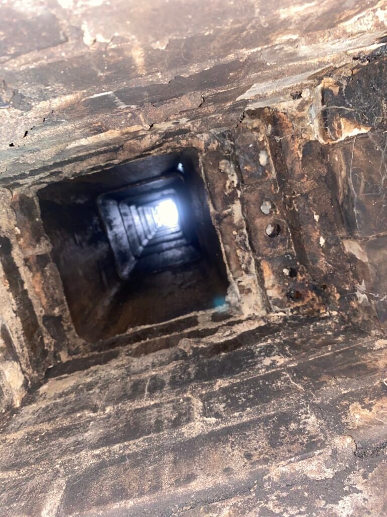 View looking up chimney flue from fireplace during inspection