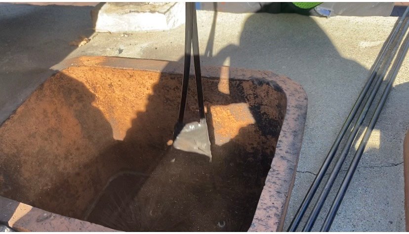 Chimney sweep cleaning a chimney from the roof using a chimney brush