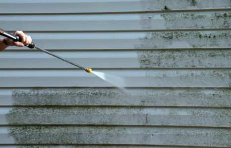 Technician pressure washing house siding in South Bend Indiana during professional exterior cleaning service